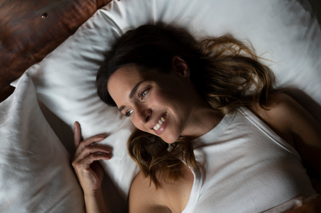 Frau lächelnd auf Bett mit vollem Haar